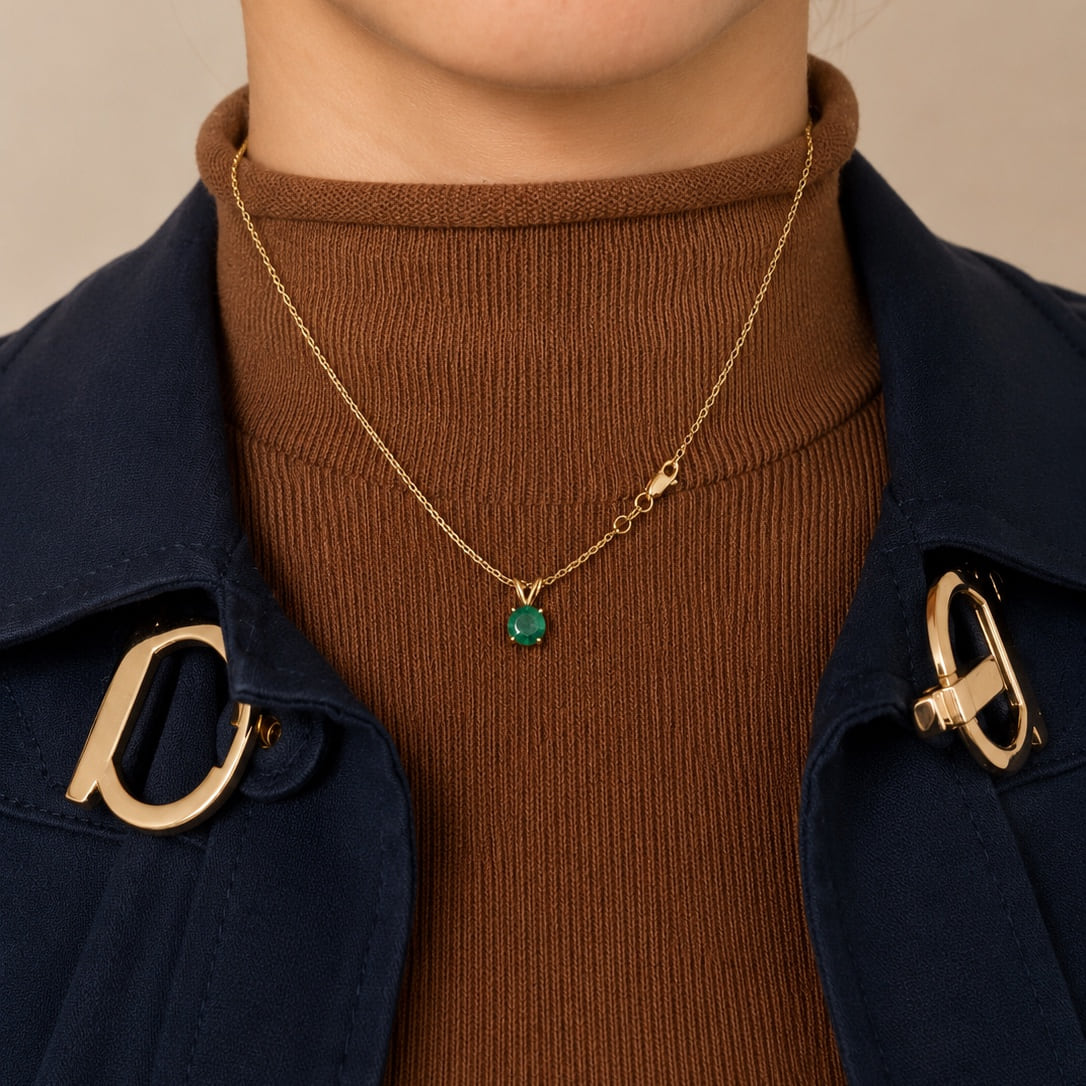 Natural emerald pendant worn with a navy coat and warm knit