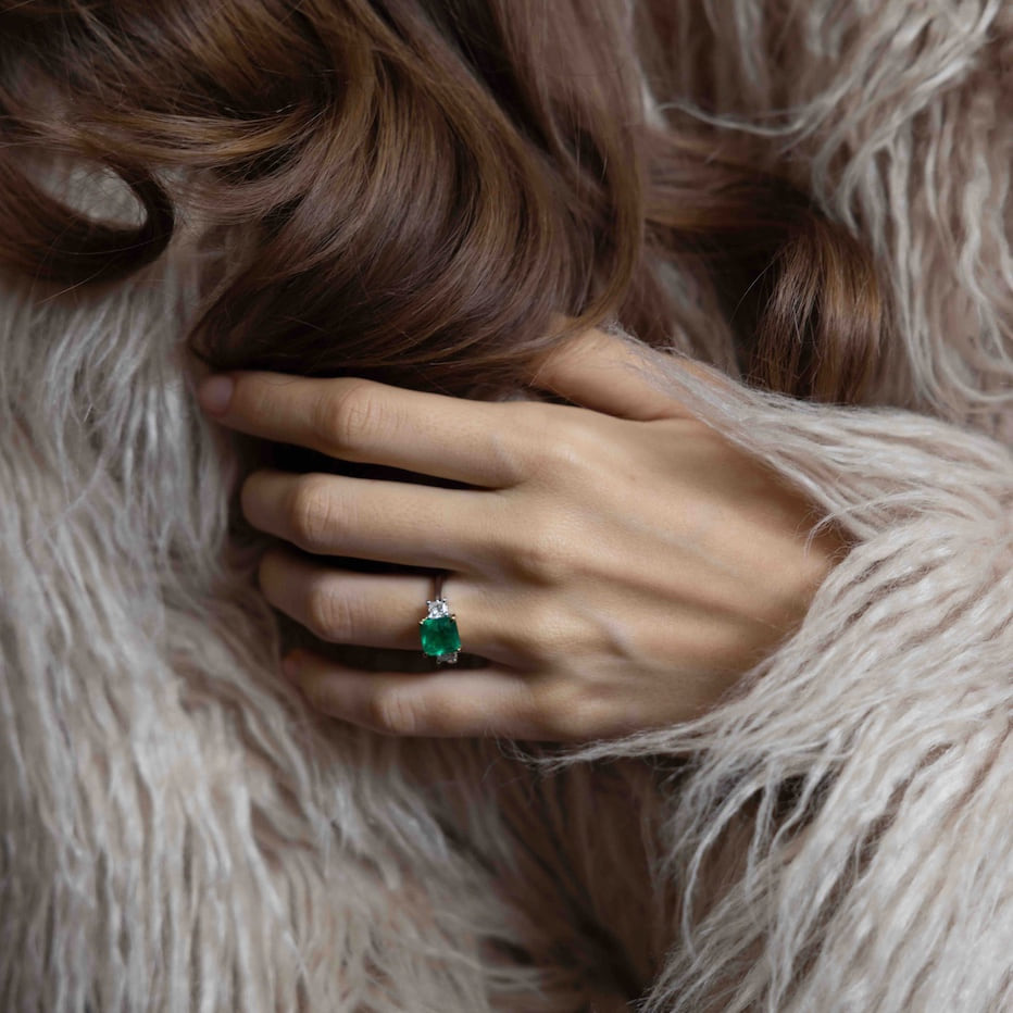 Laurenti emerald ring worn against a soft evening coat